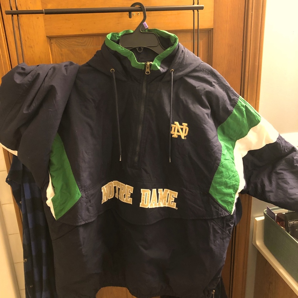 Notre Dame pull over winter jacket. Front zip pocket. Hood and cinched waist
